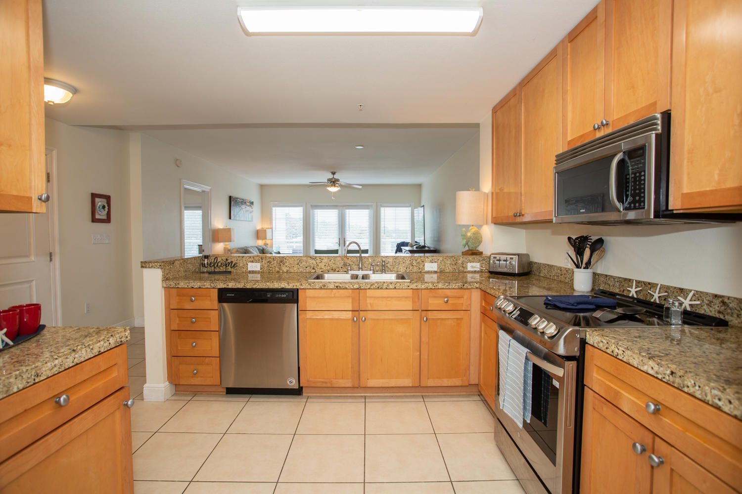 43 Cassine Way, Unit 402 Santa Rosa Beach, FL 32459 - Photo 23 of 52 a kitchen with stainless steel appliances granite countertop a stove a sink and a microwave