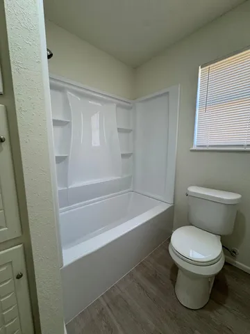 a white toilet sitting next to a bath tub