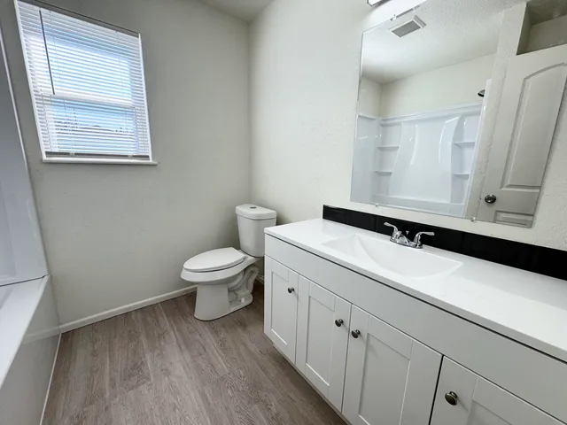 a bathroom with a sink a toilet and a window