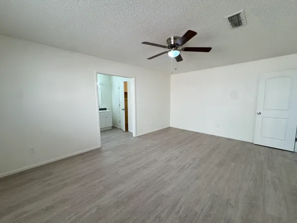 a view of a room with wooden floor and ceiling fan