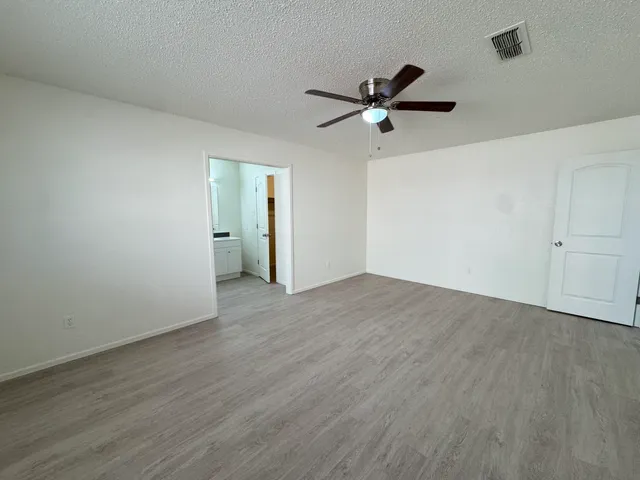 a view of a room with wooden floor and ceiling fan