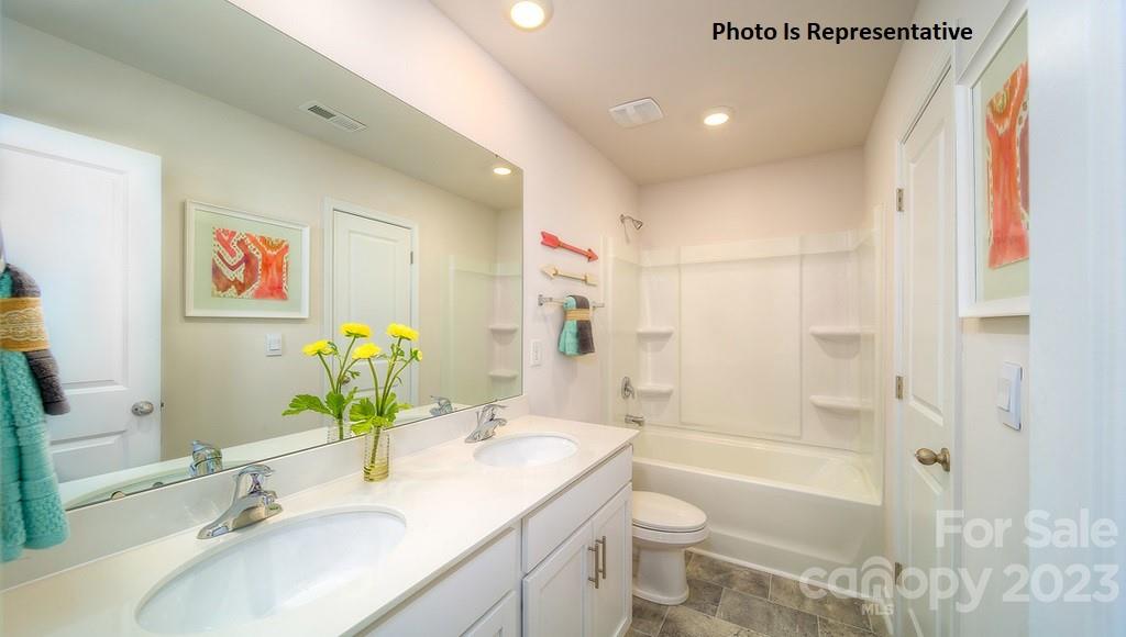 2116 Vanderlyn Street Monroe, NC 28112 - Photo 6 of 14 a bathroom with a granite countertop sink a toilet and shower