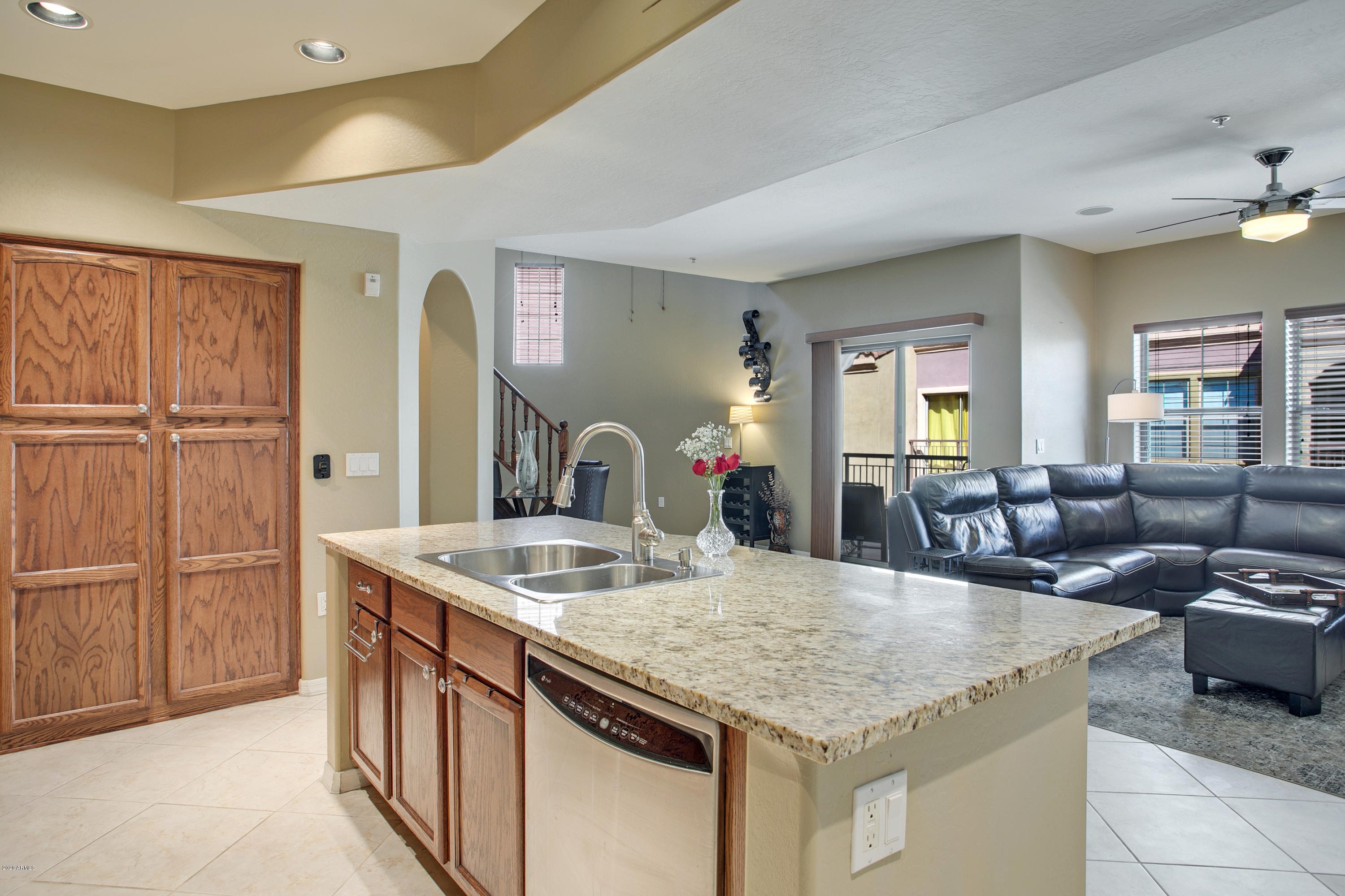 3935 East Rough Rider Road, Unit 1182 Phoenix, AZ 85050 - Photo 9 of 34 a kitchen with granite countertop a sink and white cabinets