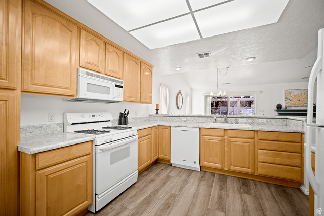 1825 West Mathis Park Place, Unit 46 St. George, UT 84770 - Photo 16 of 45 Kitchen with white appliances, light wood-style floors, light wood finish cabinetry, and light countertops