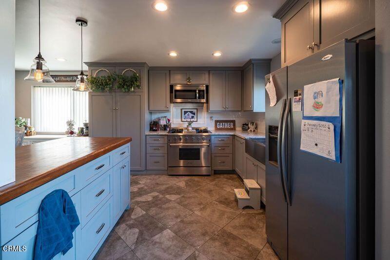 911 Indigo Place Oxnard, CA 93036 - Photo 5 of 30 a kitchen with stainless steel appliances granite countertop a sink refrigerator and cabinets