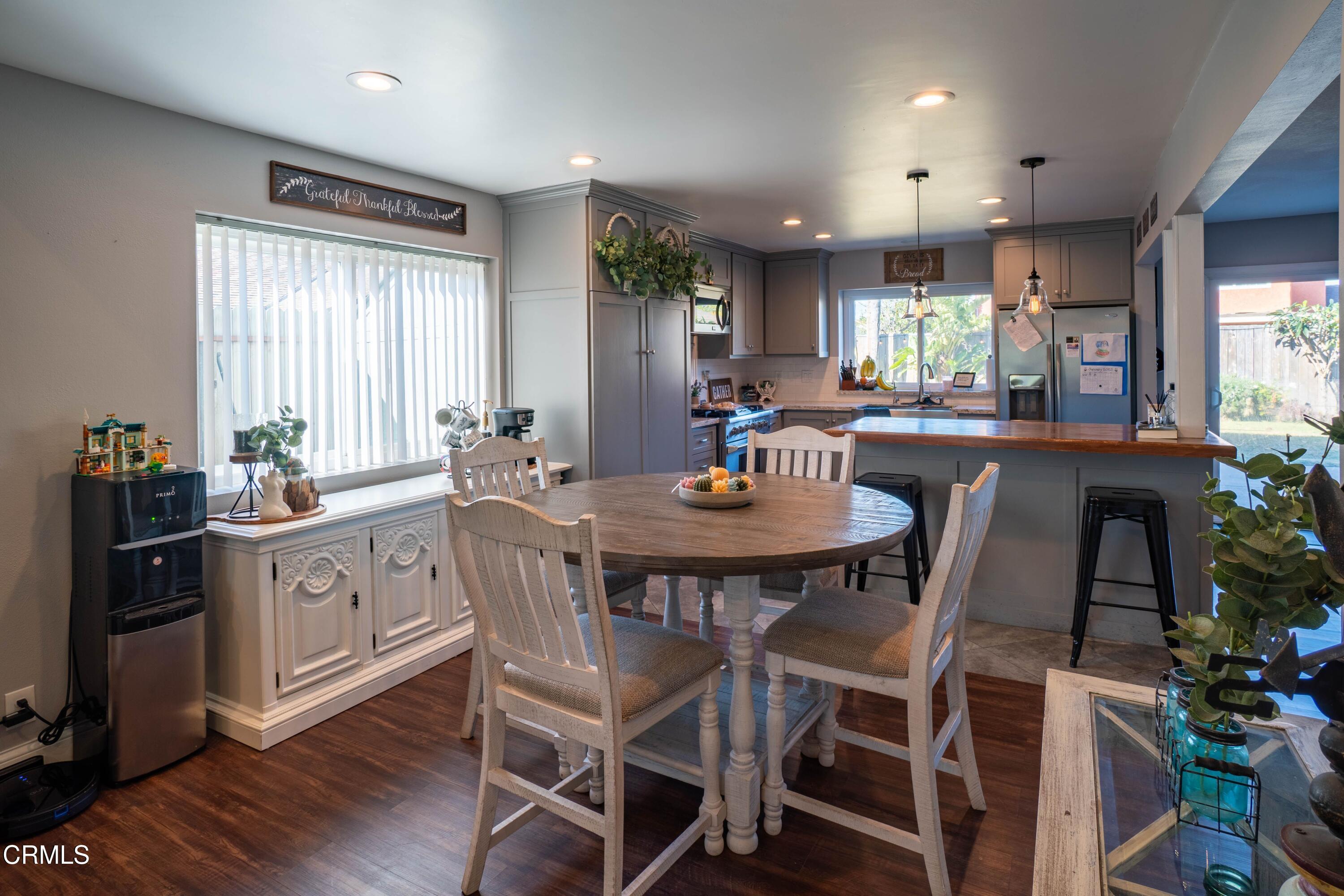 911 Indigo Place Oxnard, CA 93036 - Photo 7 of 30 a kitchen with a dining table chairs and wooden floor