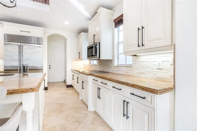 a kitchen with stainless steel appliances refrigerator cabinets and wooden floor