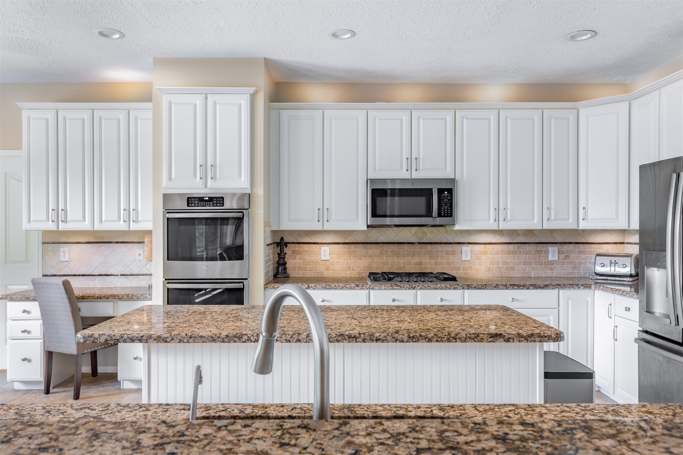 20410 Lake Spring Court Cypress, TX 77433 - Photo 17 of 50 a kitchen with stainless steel appliances kitchen island granite countertop a stove a sink and a microwave