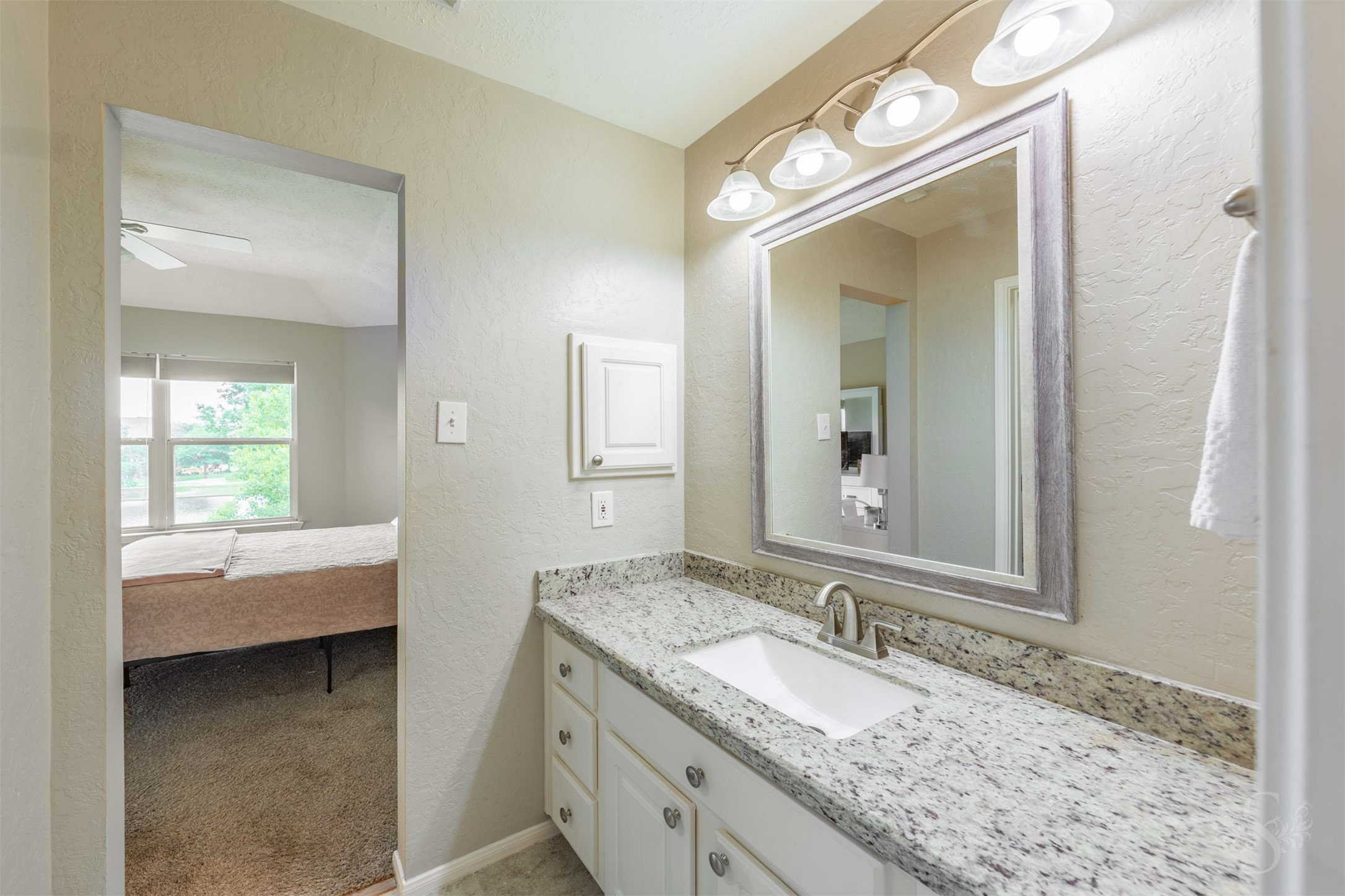 20410 Lake Spring Court Cypress, TX 77433 - Photo 38 of 50 a en suite bathroom with a granite countertop sink and a mirror