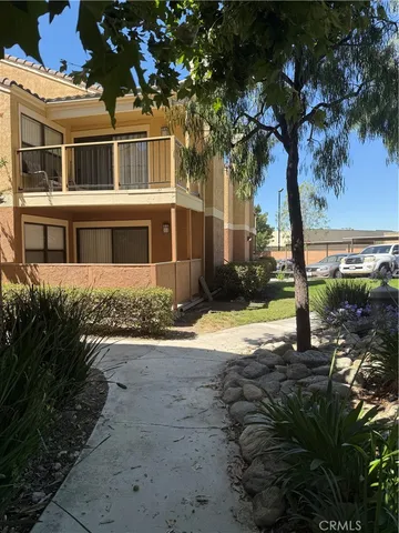 a view of a house with backyard and tree