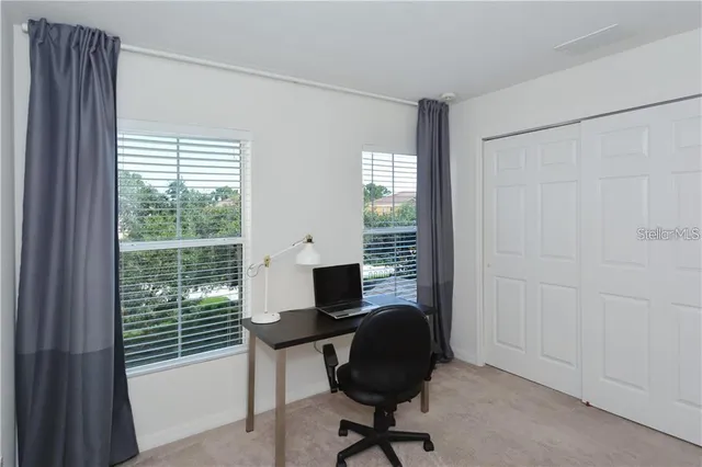 a view of a workspace with furniture and a window