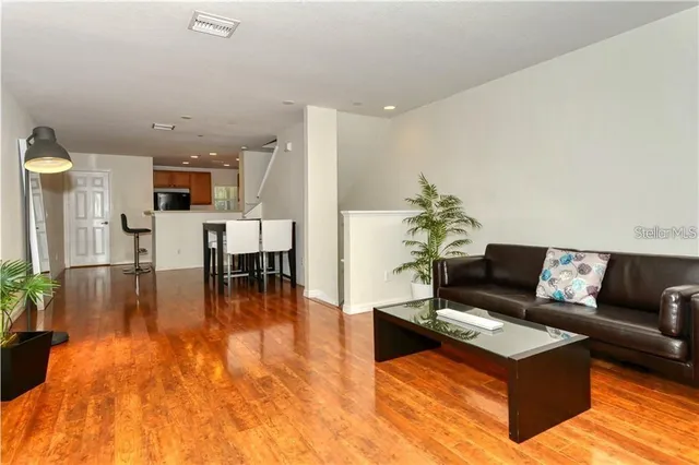 a living room with furniture and a wooden floor