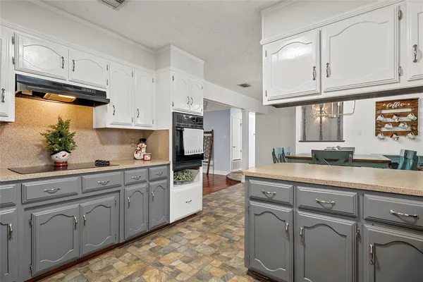 a kitchen with kitchen island granite countertop white cabinets white stainless steel appliances with a sink and dishwasher