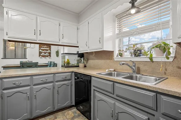 a kitchen with cabinets appliances a sink and a window
