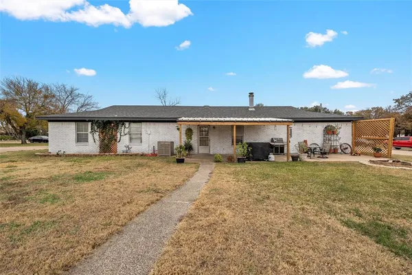 a view of a house with a yard and sitting area