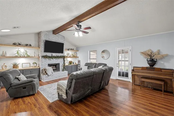 a living room with furniture a fireplace and a flat screen tv
