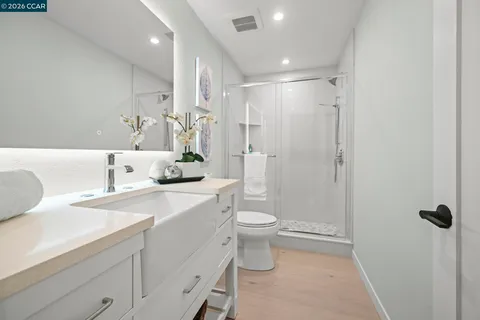 a bathroom with a sink a toilet and shower