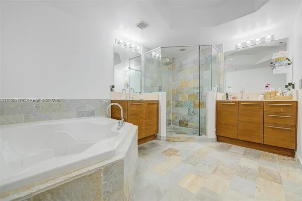 a bathroom with a bathtub sink and mirror
