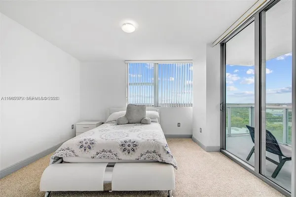 a bedroom with a large bed and a large window