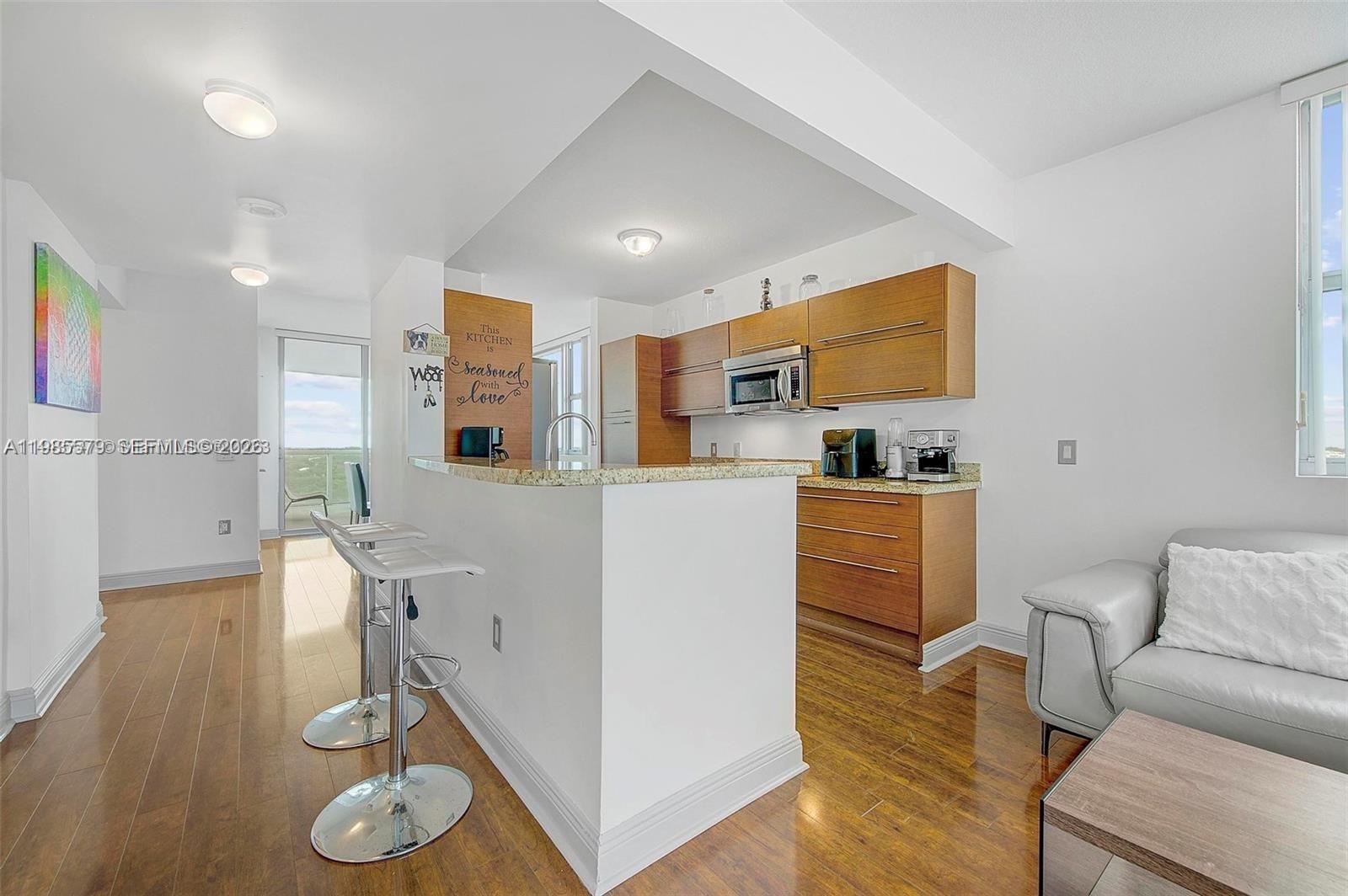 2681 North Flamingo Road, Unit 1201S Sunrise, FL 33323 - Photo 2 of 28 a living room with furniture and a wooden floor