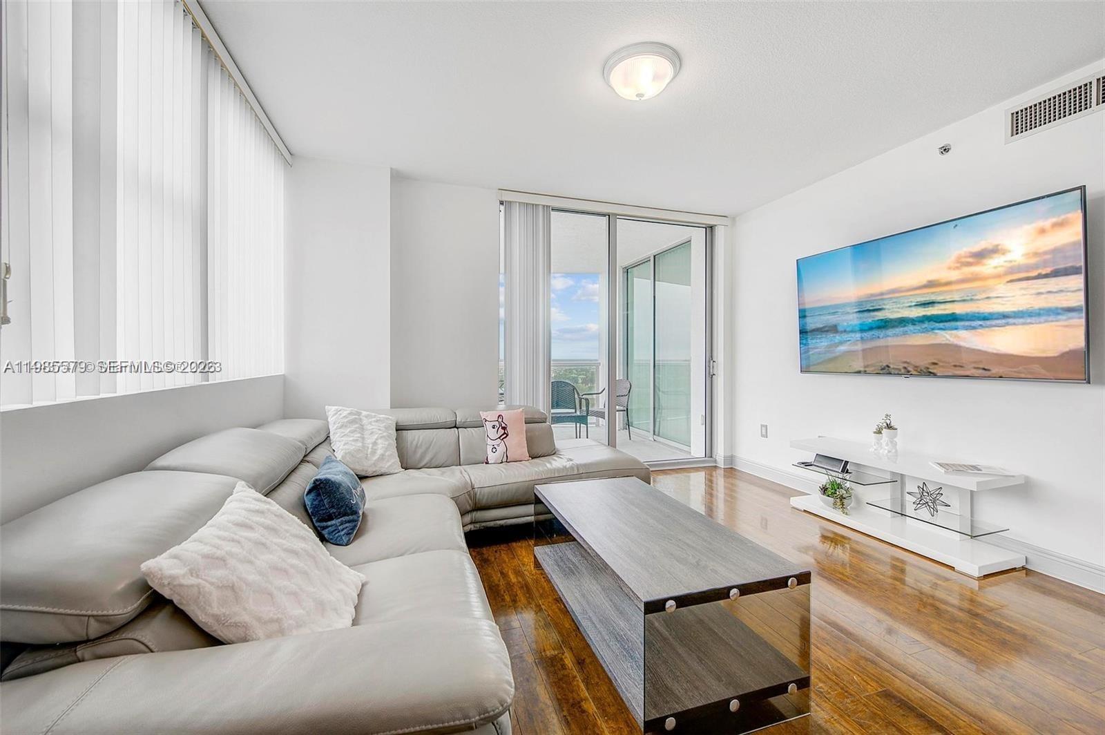 2681 North Flamingo Road, Unit 1201S Sunrise, FL 33323 - Photo 4 of 28 a living room with furniture and a flat screen tv