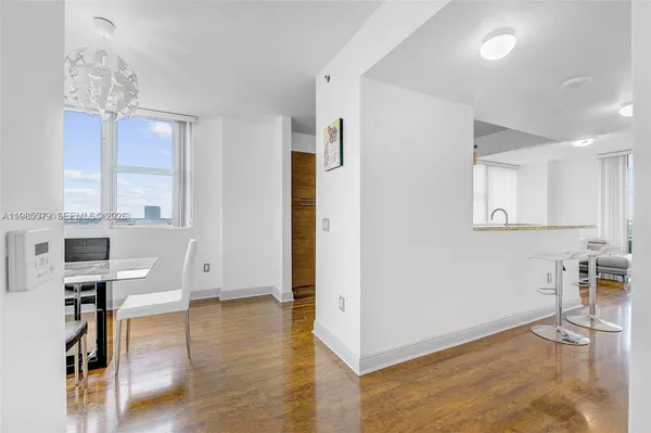 a view of a kitchen with furniture and wooden floor