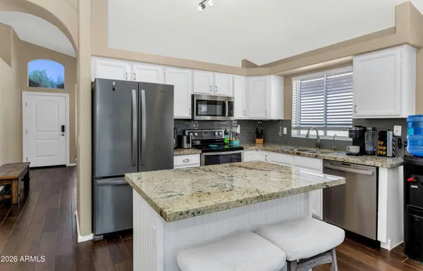 a kitchen with stainless steel appliances granite countertop a refrigerator stove microwave and sink