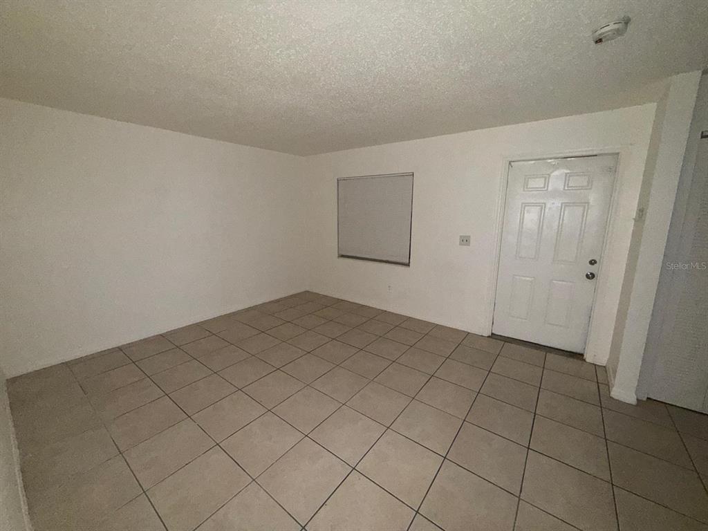 719 Michigan Court, Unit 3 St. Cloud, FL 34769 - Photo 2 of 16 a view of a room with a projector and white walls