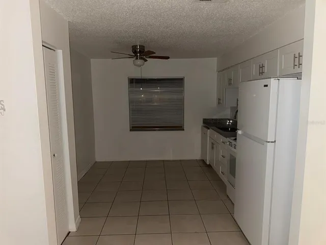 a kitchen with a refrigerator and a stove top oven