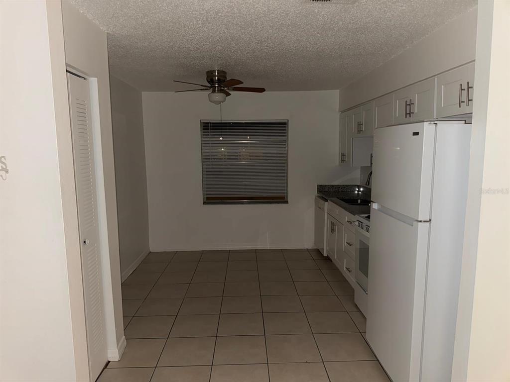 719 Michigan Court, Unit 3 St. Cloud, FL 34769 - Photo 7 of 16 a kitchen with a refrigerator and a stove top oven