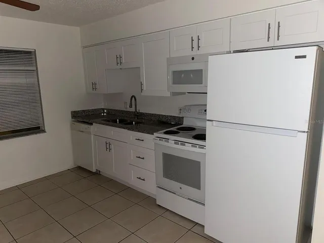 a kitchen with stainless steel appliances a refrigerator sink and cabinets