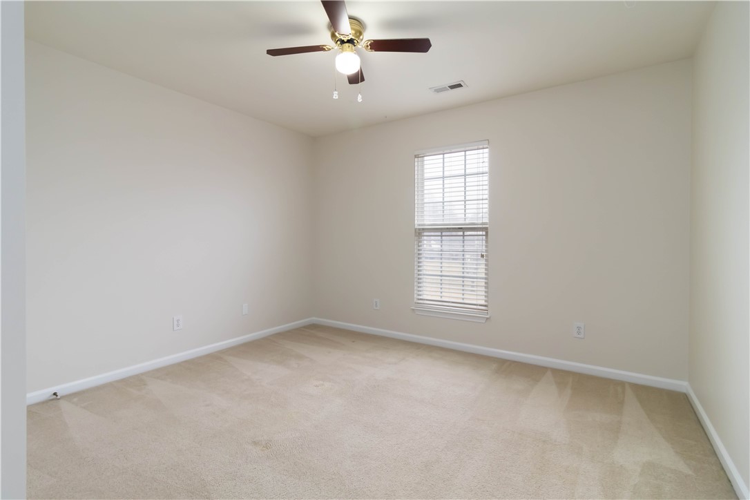 215 Ridge Bay Court Greenville, SC 29611 - Photo 19 of 34 This spacious room features neutral tones and a ceiling fan, offering a comfortable and adaptable living space.