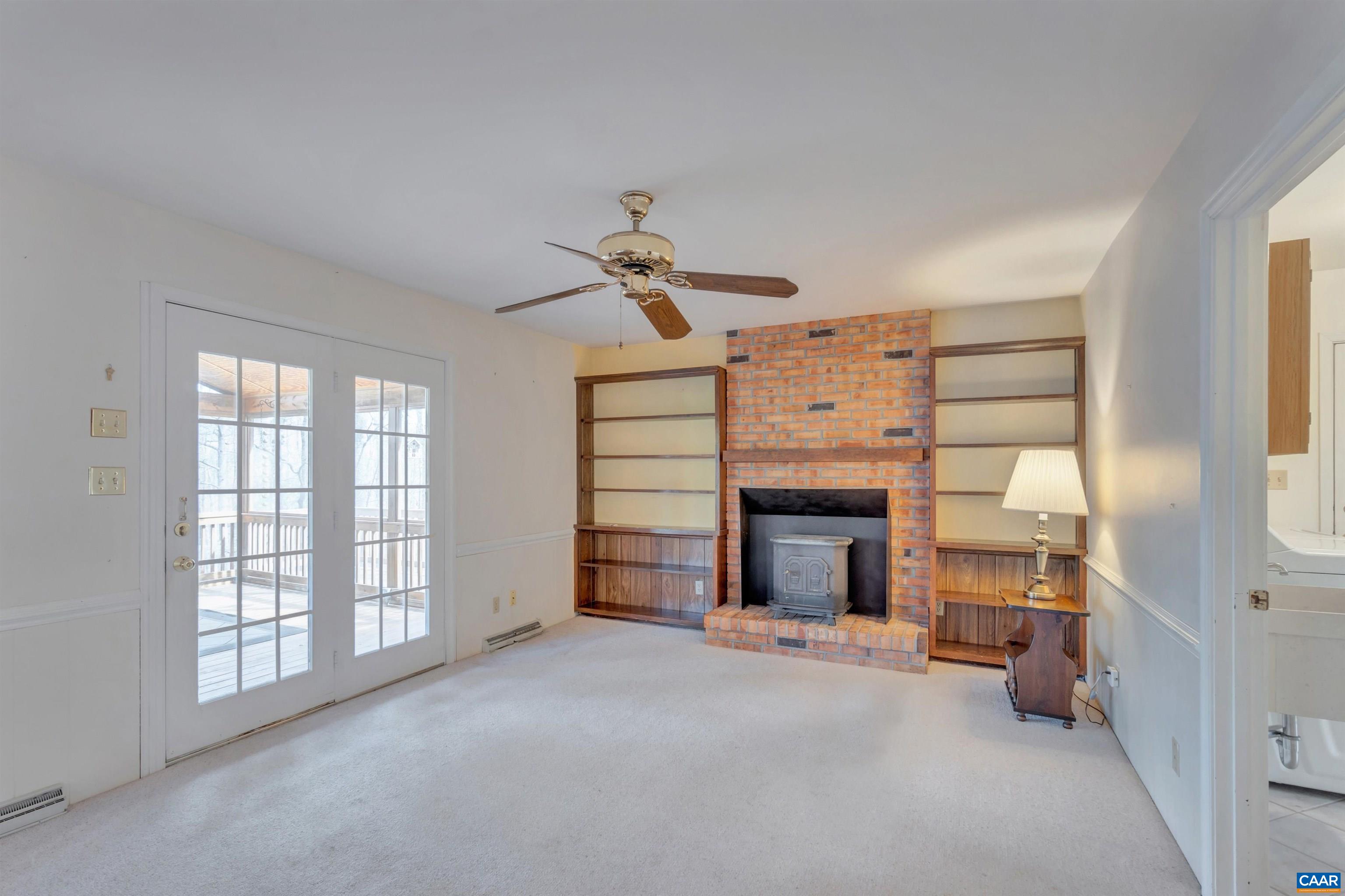 2091 Whippoorwill Road Charlottesville, VA 22901 - Photo 11 of 41 a view of a livingroom with a fireplace a ceiling fan and windows