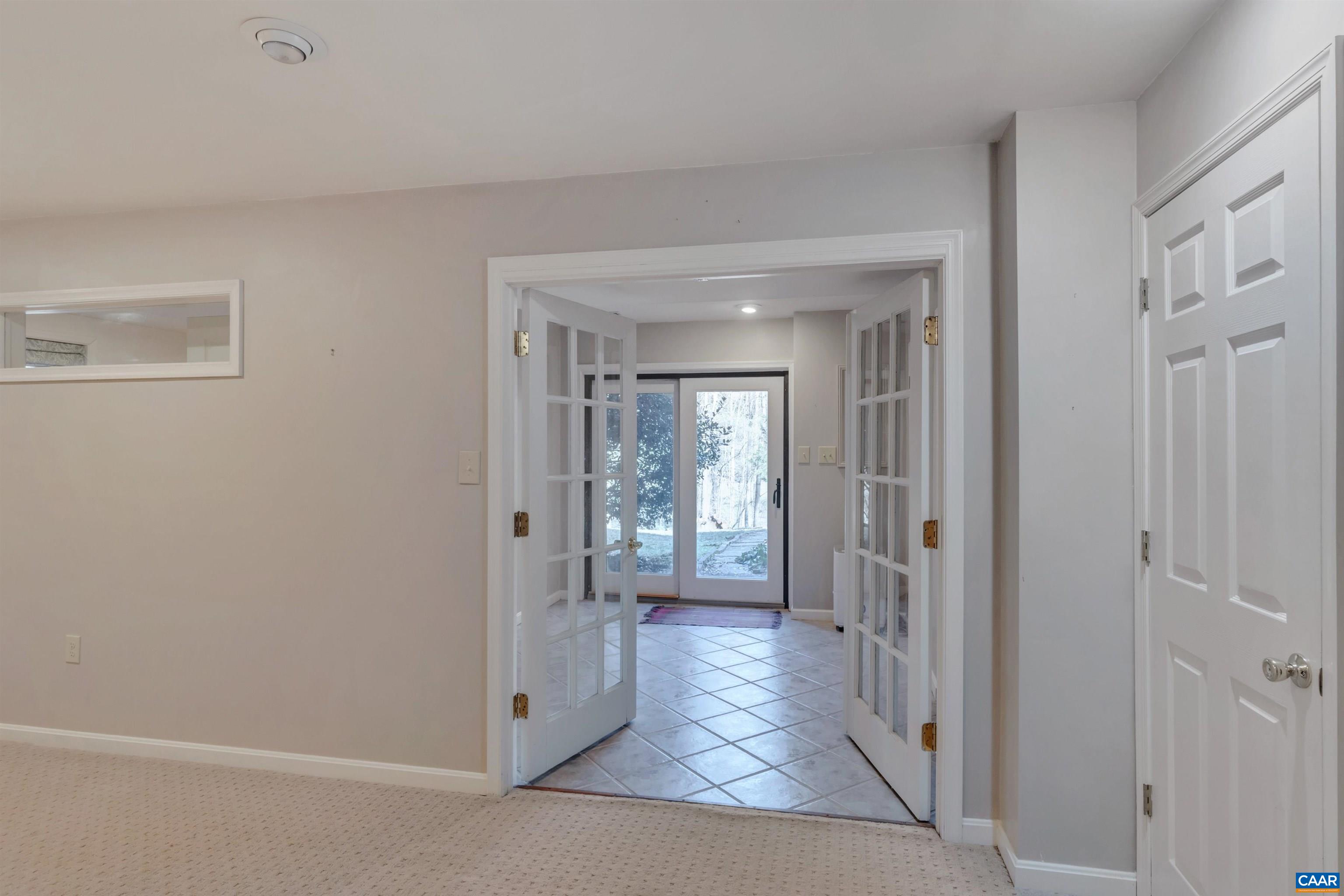 2091 Whippoorwill Road Charlottesville, VA 22901 - Photo 26 of 41 a view of a hallway with wooden floor and a living room