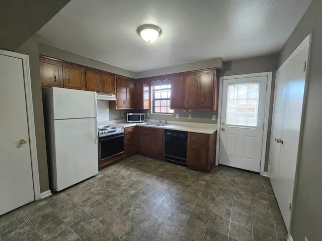 a kitchen with a refrigerator a sink and cabinets