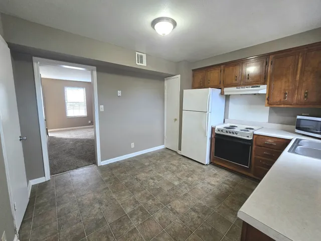 a kitchen with kitchen island granite countertop a stove and a refrigerator