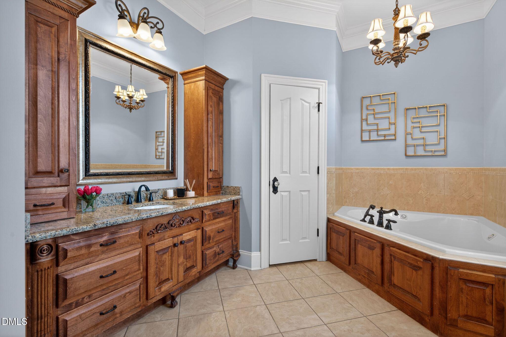 1609 Holland Road Fuquay-Varina, NC 27526 - Photo 30 of 79 a bathroom with a double vanity sink a mirror a bathtub and a window