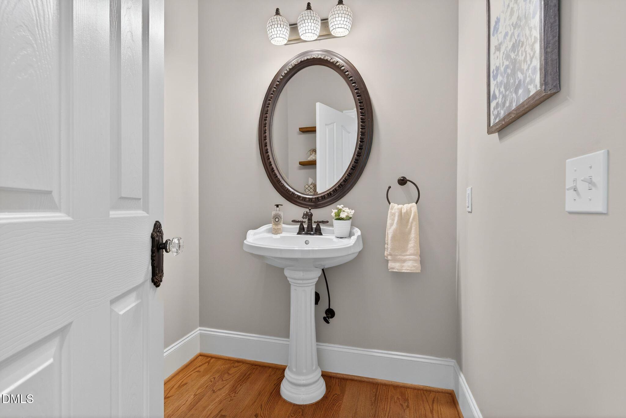 1609 Holland Road Fuquay-Varina, NC 27526 - Photo 33 of 79 a bathroom with a sink a mirror a lamp and window