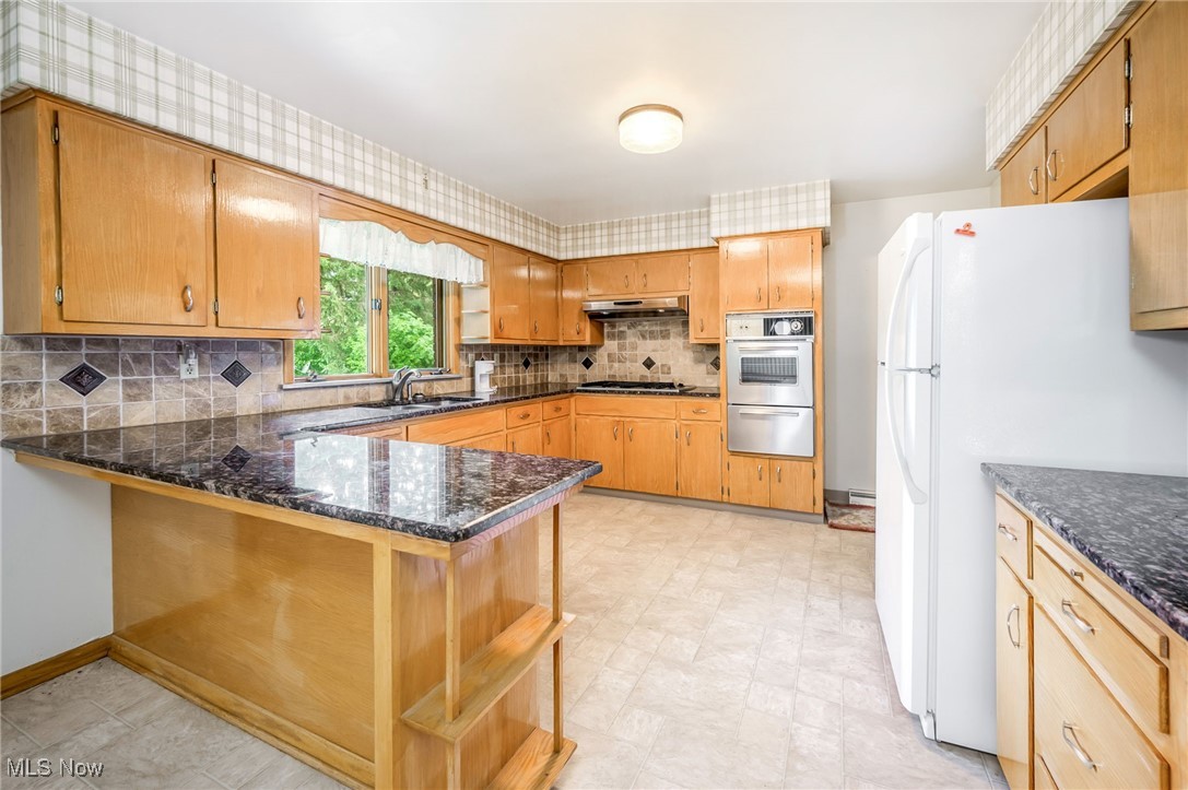 126 South Rhodes Avenue Niles, OH 44446 - Photo 7 of 23 Kitchen featuring kitchen peninsula, sink, tasteful backsplash, and light tile floors
