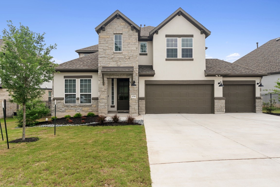 a front view of a house with a yard and trees