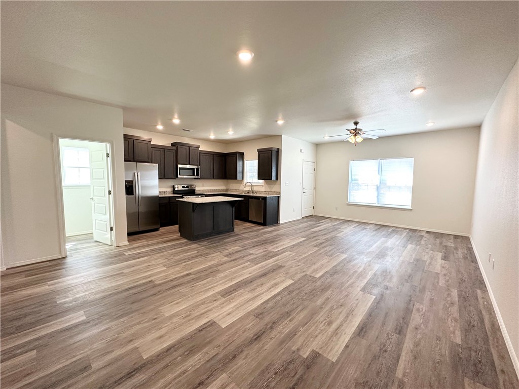 Open concept living area featuring wood-look flooring, recessed lighting, and a ceiling fan