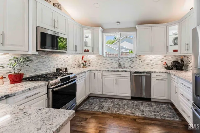 a kitchen with granite countertop a sink stove and cabinets