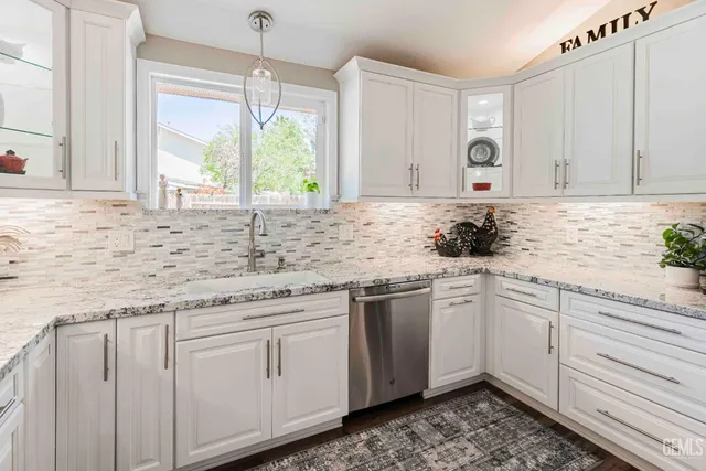 a kitchen with granite countertop white cabinets and white appliances