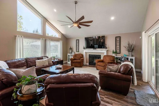 a living room with furniture a flat screen tv and a large window