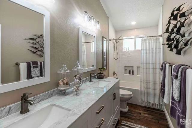 a bathroom with double vanity and a mirror