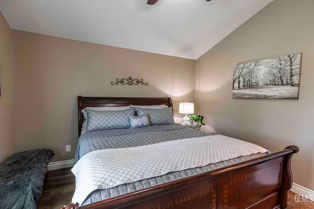 a bedroom with a bed and paintings on the wall