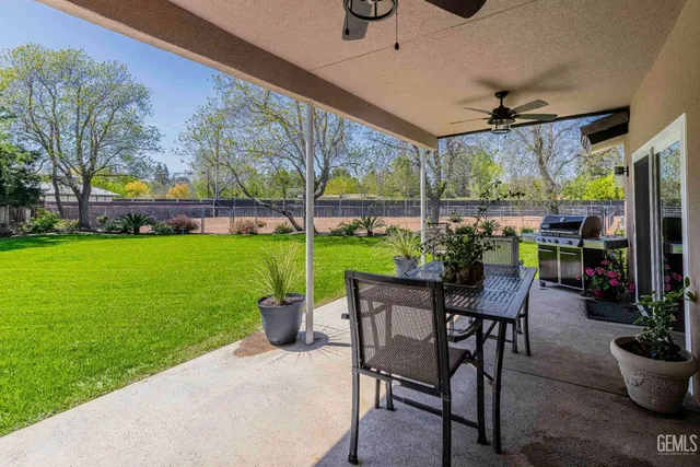 a view of a patio with a table chairs and a yard