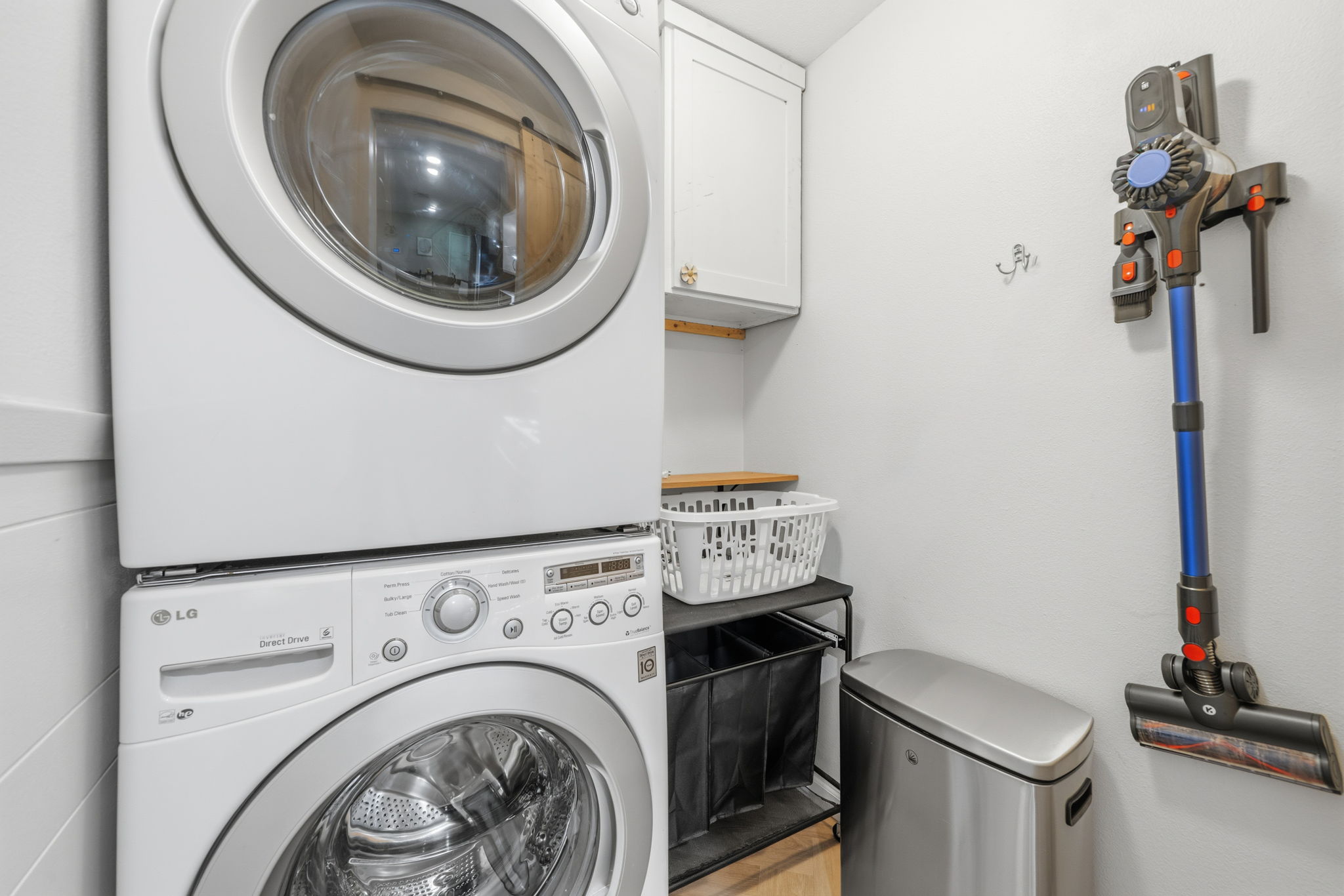 705 Dulwich Street Austin, TX 78748 - Photo 11 of 36 Practical laundry space offers stacked appliances and convenient storage solutions.