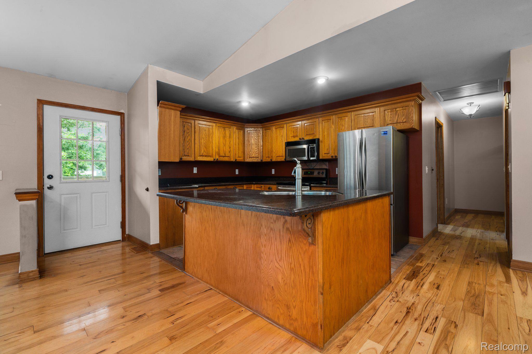5760 Mason Road Fowlerville, MI 48836 - Photo 3 of 23 Nice island seating w/ wood cabinets & appliances