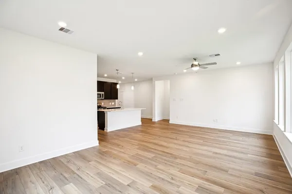 a view of a kitchen with kitchen island granite countertop cabinets and wooden floor